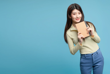  蓝色背景里，正在看书的亚洲美女