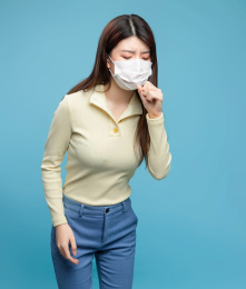  蓝色背景里，带着口罩的亚洲美女