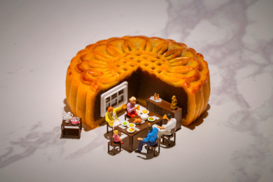 一家人坐在月饼边上团聚吃饭