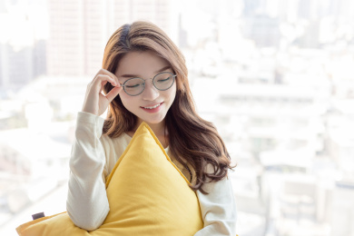 一名戴眼镜的年轻女性坐在窗台上休息