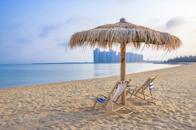 中国海南海边沙滩上的草亭和躺椅