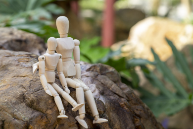 两个木偶在岩石上依偎坐着