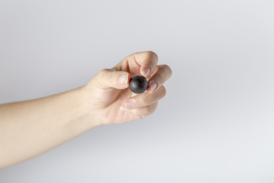 白色背景一只手拿着一颗中成药药丸特写