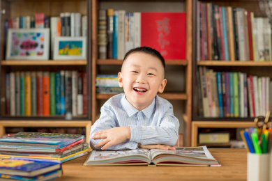 亚洲男孩在明亮的室内书架前学习画画