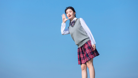 蓝色天空背景下，正在呐喊的亚洲女学生
