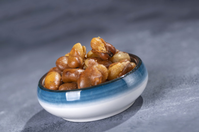 一碟油炸兰花豆特写旁边放有酒壶酒杯茶杯