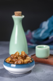 一碟油炸兰花豆特写旁边放有酒壶酒杯茶杯