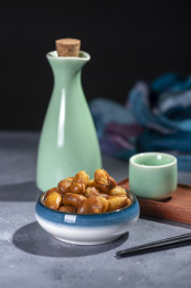 一碟油炸兰花豆特写旁边放有酒壶酒杯茶杯