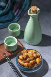 一碟油炸兰花豆特写旁边放有酒壶酒杯茶杯
