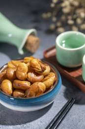一碟油炸兰花豆特写旁边放有酒壶酒杯茶杯