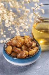 一碟油炸兰花豆特写旁边放有酒壶酒杯茶杯