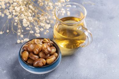 一碟油炸兰花豆特写旁边放有酒壶酒杯茶杯