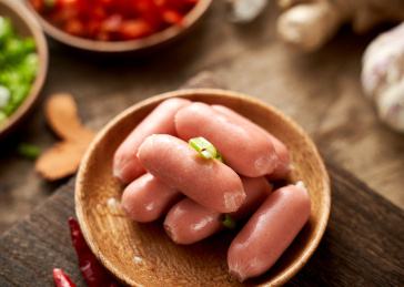 木桌上餐具里摆放的脆皮肠