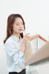 一中国年轻女商务女士闭眼闻咖啡的香味