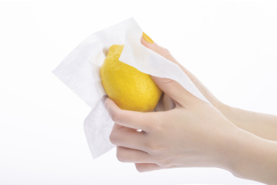 白色背景下用棉柔巾擦柠檬