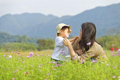 一个女性妈妈带着小男孩在花丛中