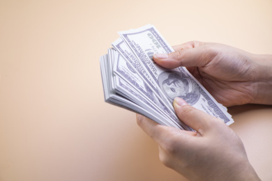 纯色背景中的手里拿着现金