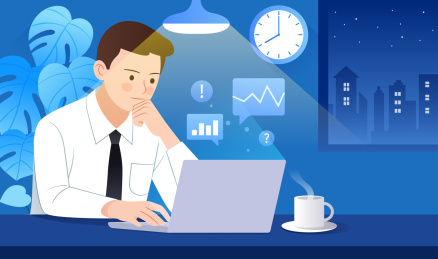 一个商务男士在晚上对着电脑工作