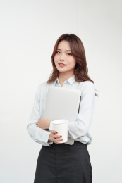 抱着电脑的年轻东方商务女士