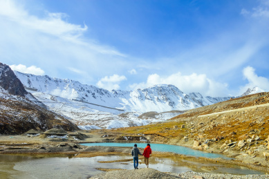 亚裔情侣在新疆省独库公路上翻越天山山脉