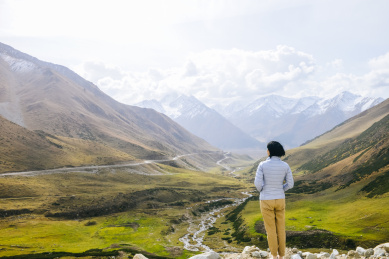 亚裔女性看向中国新疆省独库公路沿途的峡谷