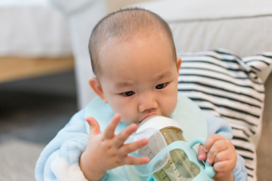 房间里穿着睡衣在吃奶的婴儿