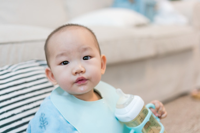 房间里穿着睡衣在吃奶的婴儿