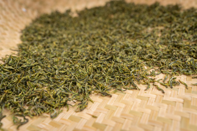 平铺在竹筐里的绿茶茶叶