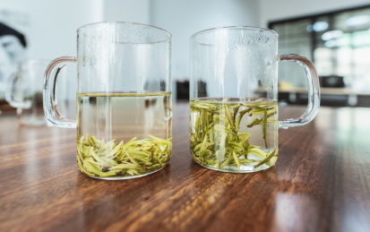 玻璃杯中漂浮在水中的茶叶与沉底茶叶对比