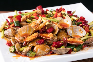 方盘里的筷子夹着的麻辣爆炒花甲