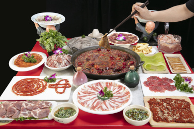 筷子夹着正在烫火锅一桌子配菜