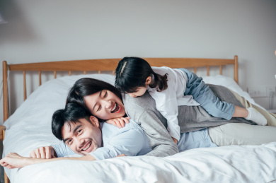 爸爸妈妈和女儿在卧室做游戏