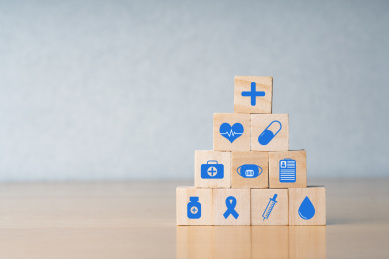 手拿着画着医疗图标的木块保险安全概念