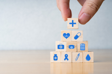 手拿着画着医疗图标的木块保险安全概念