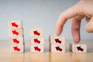 手踩着积木和向上的箭头表达进步