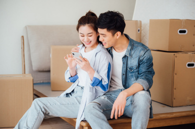 亚洲年轻情侣在新家使用手机