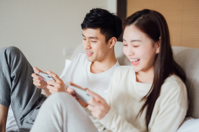 亚洲年轻情侣在家使用智能手机