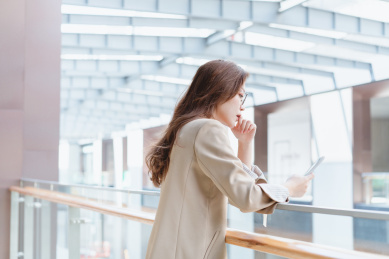 年轻女生依靠在栏杆上玩手机