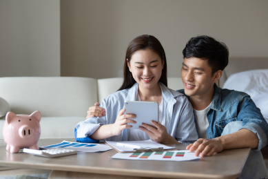 一对年轻的亚洲情侣在坐在地毯上做规划