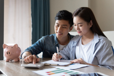 一对年轻的亚洲情侣在坐在地毯上做规划