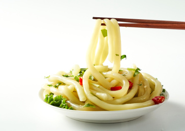 白色背景上筷子夹起的南瓜土豆粉