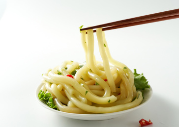 白色背景上筷子夹起的南瓜土豆粉