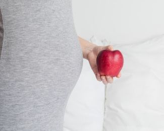 孕妇手拿着一只红色的苹果