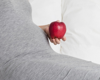 孕妇手拿着一只红色的苹果