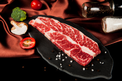 深色背景下放在黑色岩石盘子上的雪花生牛排