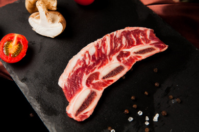 深色背景下放在黑色岩石盘子上的雪花生牛排