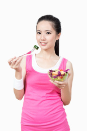 年轻女孩吃水果和蔬菜