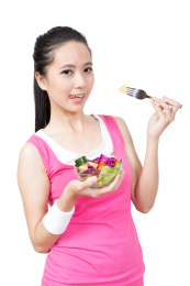 年轻女孩吃水果和蔬菜