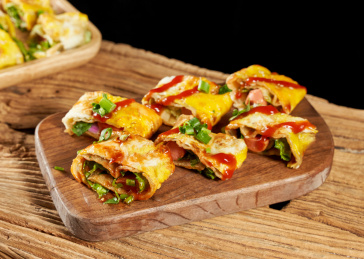 木桌上餐具上摆放的东北烤冷面