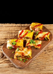 木桌上餐具上摆放的东北烤冷面